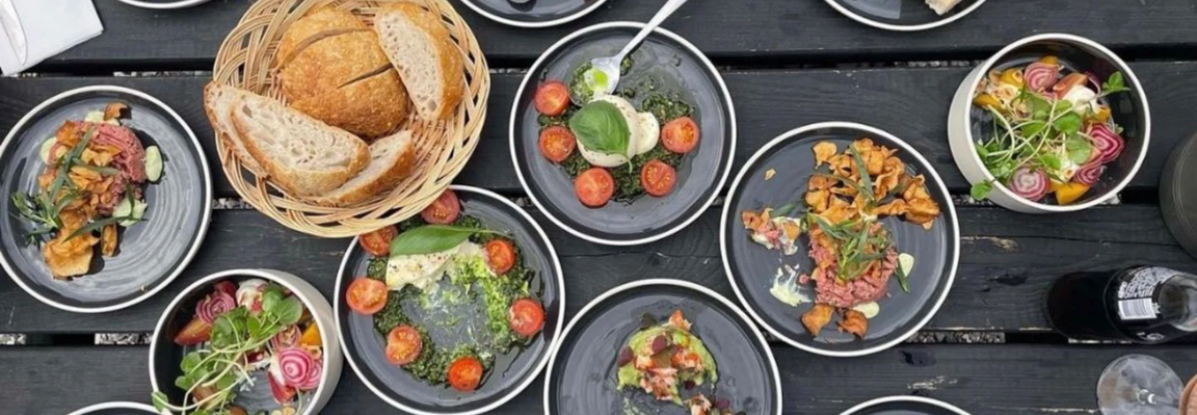 Små hjemmelavede retter og friskbagt brød på et langbord hos Bings